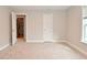 A bedroom boasts neutral walls, carpet, walk-in closet, and a white paneled door at 3930 Towhees Dr, Indianapolis, IN 46237