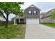 Two-story brick home with a large front yard and an attached two-car garage at 3930 Towhees Dr, Indianapolis, IN 46237