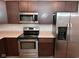 Modern kitchen featuring stainless steel appliances, granite countertops, and dark wood cabinets at 3930 Towhees Dr, Indianapolis, IN 46237