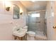 Bathroom featuring shower with glass doors, sink, toilet, and textured wallpaper at 415 S East St, Plainfield, IN 46168