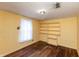 Bedroom with wood floors, built-in shelves, one window and painted yellow walls at 415 S East St, Plainfield, IN 46168