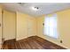 Bedroom features light yellow walls, wood flooring, window with curtain, and standard closet at 415 S East St, Plainfield, IN 46168