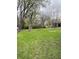 Green backyard featuring mature trees and a spacious lawn great for outdoor activities at 4206 Clark St, Anderson, IN 46013