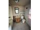 Bathroom in need of renovation, featuring a vintage sink, toilet, and a partially tiled wall at 4206 Clark St, Anderson, IN 46013