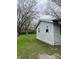 Exterior side view of a single-story house, showcasing the yard and weathered siding at 4206 Clark St, Anderson, IN 46013