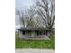 Inviting single-story home with a covered front porch and mature trees, offering a cozy curb appeal at 4206 Clark St, Anderson, IN 46013