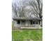 Cozy home exterior featuring a covered front porch, small yard, and inviting entry at 4206 Clark St, Anderson, IN 46013