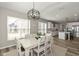 A dining room opens to the kitchen, with an island, white cabinets and stainless steel appliances at 4333 Ironclad Dr, Bargersville, IN 46106
