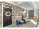 Inviting front porch with stone accents, seating area, and black front door with wreath at 4333 Ironclad Dr, Bargersville, IN 46106