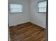 A bright bedroom featuring hardwood floors and plenty of natural light from the two windows at 5209 S Bancroft St, Indianapolis, IN 46237