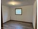 Cozy bedroom features neutral walls, window with blinds, wood trim, and durable wood-look floors at 5209 S Bancroft St, Indianapolis, IN 46237