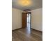 Bedroom with door leading to kitchen area, light-colored walls, and wood-look floors at 5209 S Bancroft St, Indianapolis, IN 46237