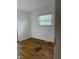 The bedroom features classic hardwood flooring and a sunny window with blinds at 5209 S Bancroft St, Indianapolis, IN 46237