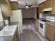 Open kitchen featuring wood cabinets, gray countertops, an electric range and a sink overlooking the living area at 5209 S Bancroft St, Indianapolis, IN 46237