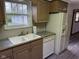 Charming kitchen featuring wood cabinets, gray countertops, white appliances, and a window overlooking the yard at 5209 S Bancroft St, Indianapolis, IN 46237