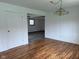 Open-concept living room features wood floors, decorative paneling, and a modern light fixture at 5209 S Bancroft St, Indianapolis, IN 46237