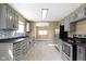 Well-lit kitchen with neutral cabinets, stainless steel appliances, and mosaic tile backsplash at 525 S Keystone Ave, Indianapolis, IN 46203