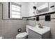 Updated bathroom features gray tile, classic black trim, and a modern sink and vanity at 5802 Crittenden Ave, Indianapolis, IN 46220