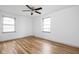 Bright bedroom with hardwood floors, ceiling fan, and natural light from two windows at 5802 Crittenden Ave, Indianapolis, IN 46220