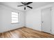 Bright bedroom with hardwood floors, ceiling fan, and natural light from a window at 5802 Crittenden Ave, Indianapolis, IN 46220