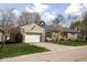 Charming stone home with an attached garage, a well-manicured lawn, and a cozy front porch at 5802 Crittenden Ave, Indianapolis, IN 46220