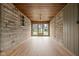 Spacious sunroom features stone walls, a wood ceiling, and large glass doors to the backyard at 5802 Crittenden Ave, Indianapolis, IN 46220