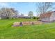 Large backyard features raised garden beds, green grass, and trees at 5925 Leisure Ln, Pittsboro, IN 46167