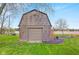 Weathered barn with tan garage door, surrounded by bright green grass at 5925 Leisure Ln, Pittsboro, IN 46167