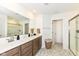 Well-lit bathroom featuring double sinks, a large mirror, and glass-enclosed shower at 605 Tuscany Trl, Lapel, IN 46051