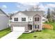 Charming two-story home features a brick facade, attached two-car garage, and manicured front lawn at 605 Tuscany Trl, Lapel, IN 46051