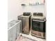 Modern laundry room with stainless steel washer and dryer, plus a rolling laundry basket at 605 Tuscany Trl, Lapel, IN 46051