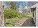 View of a backyard with grass, mulch, a privacy fence, and two wooden chairs with a small fire pit at 6153 Evanston Ave, Indianapolis, IN 46220