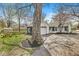 Exterior view of a home with a two-car garage, driveway, manicured landscaping, and a painted shed with modern art at 6153 Evanston Ave, Indianapolis, IN 46220