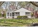 Charming single-story home showcasing a well-maintained lawn, blossoming trees, and a cozy enclosed porch at 6153 Evanston Ave, Indianapolis, IN 46220