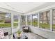Bright sunroom filled with natural light from numerous windows, featuring comfortable seating and views of the outdoors at 6153 Evanston Ave, Indianapolis, IN 46220