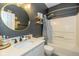 Bathroom featuring a round mirror, vanity, shower, and elegant black accent wall at 6328 Dusty Laurel Dr, Whitestown, IN 46075