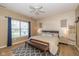 Comfortable bedroom with a ceiling fan, wooden bench, and window with natural light and blue curtains at 6328 Dusty Laurel Dr, Whitestown, IN 46075