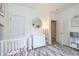 Well-lit Bedroom featuring a white crib, dresser, and round mirror creating a serene and inviting space at 6328 Dusty Laurel Dr, Whitestown, IN 46075
