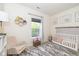 Bright Bedroom with a crib, rocking chair, neutral decor, and large window at 6328 Dusty Laurel Dr, Whitestown, IN 46075