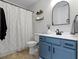 Bathroom featuring a blue vanity, updated fixtures, and neutral tiling at 6586 W Winding Bnd, McCordsville, IN 46055