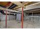 Unfinished basement featuring exposed duct work, red support beams, and a concrete floor at 67 S 9Th Ave, Beech Grove, IN 46107