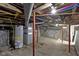 Unfinished basement displaying exposed plumbing, red support beams, and a concrete floor at 67 S 9Th Ave, Beech Grove, IN 46107