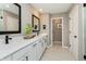 Well-lit bathroom showcasing double vanity, quartz countertop, sleek fixtures, and ceramic tile flooring at 7076 Portico Ln, McCordsville, IN 46055