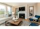Inviting living room with fireplace, modern decor, neutral sofa, and natural light from large windows at 7076 Portico Ln, McCordsville, IN 46055