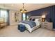 Serene main bedroom with accent wall, plush carpet, a stylish chandelier, and abundant natural light at 7076 Portico Ln, McCordsville, IN 46055