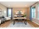 Inviting home office showcasing wood flooring, natural light, and stylish decor at 7076 Portico Ln, McCordsville, IN 46055