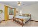 Cozy bedroom featuring carpet, a ceiling fan, and a large window with yellow curtains at 7113 Lakeside Woods Dr, Indianapolis, IN 46278