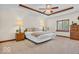 Bright main bedroom featuring tray ceilings, a ceiling fan and carpet floors at 7113 Lakeside Woods Dr, Indianapolis, IN 46278