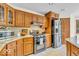Kitchen showcasing stainless steel appliances, wooden cabinetry, and granite countertops at 7113 Lakeside Woods Dr, Indianapolis, IN 46278