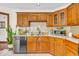Kitchen area with granite countertops, stainless dishwasher, and wooden cabinets at 7113 Lakeside Woods Dr, Indianapolis, IN 46278